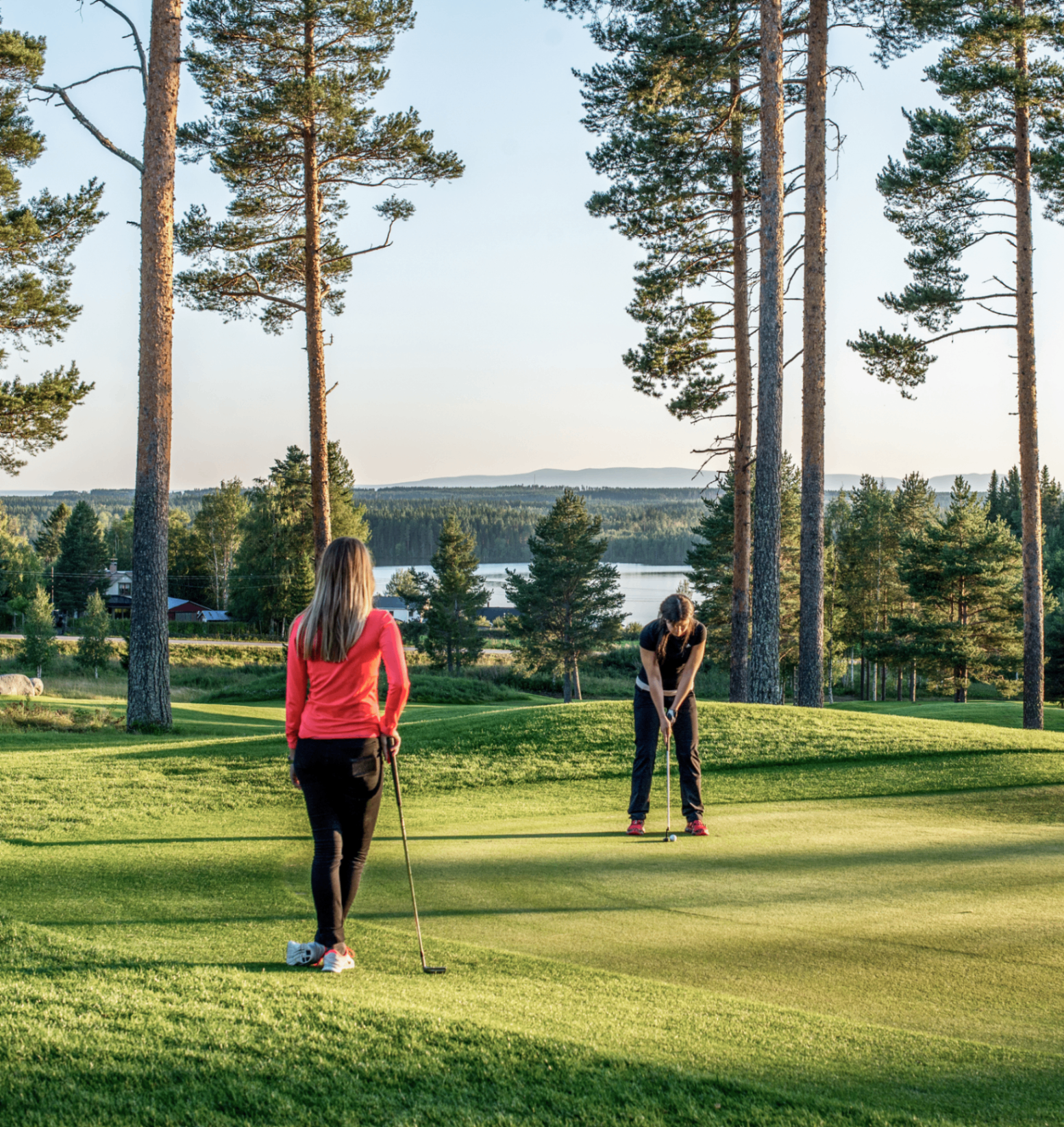 Spelare på green med utsikt över sjön